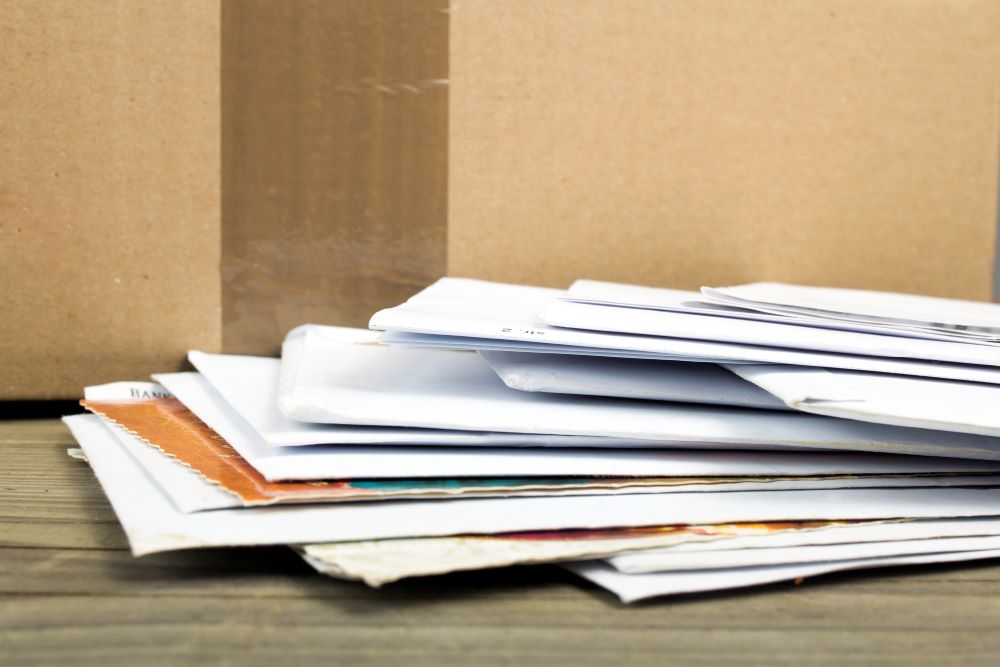 A stack of business mail on a desk signifying the need for in-house mailing equipment for Cary businesses.